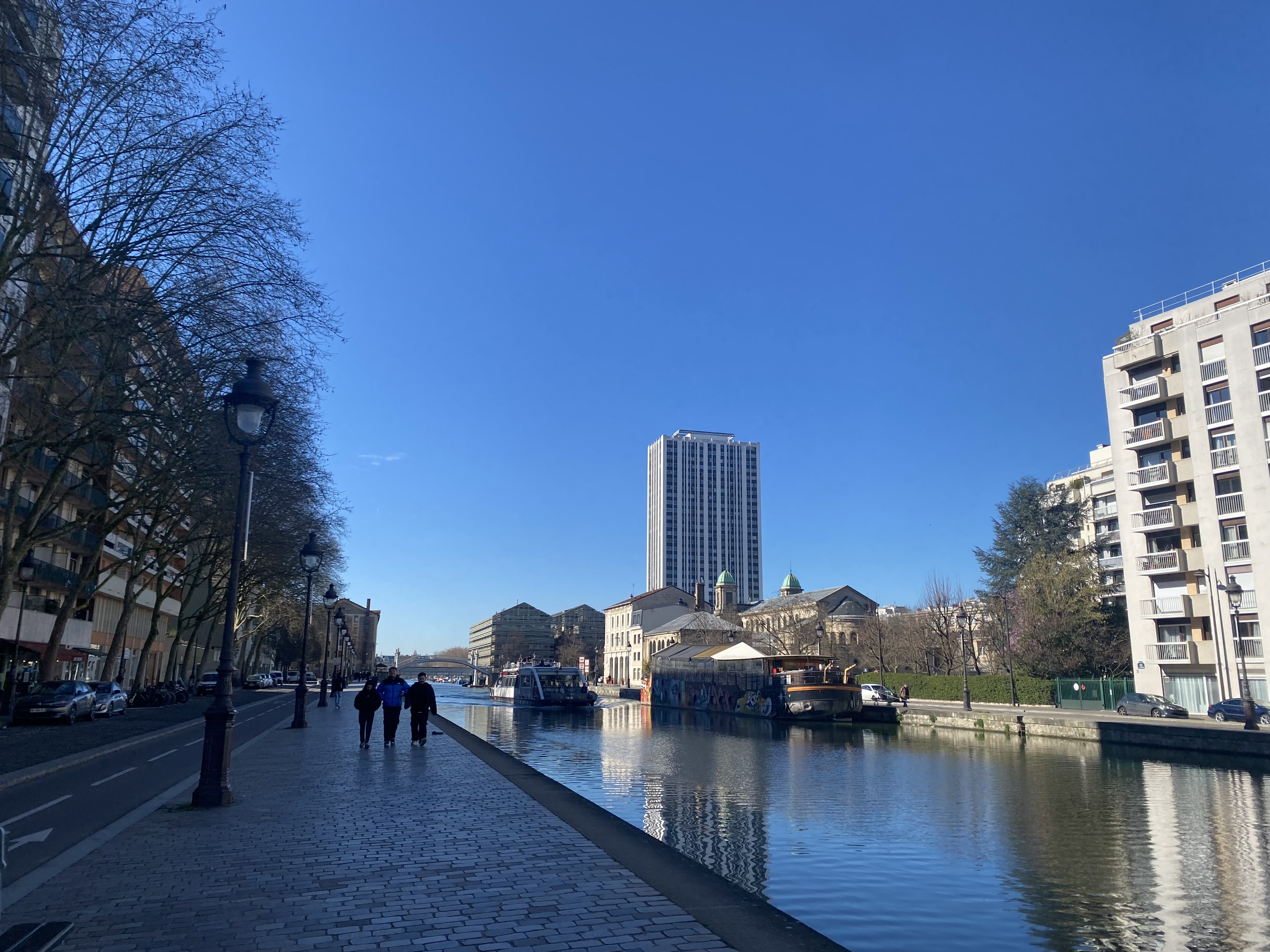 Wide canal view with boats and blue sky